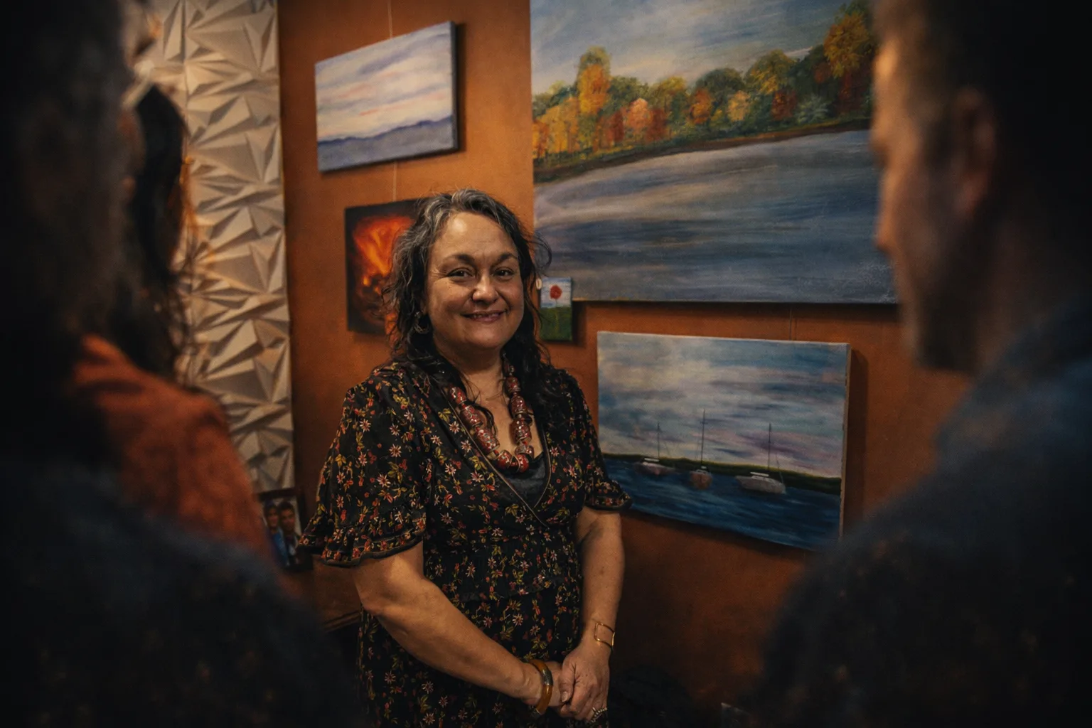 Karina Mott standing among her paintings at a gallery opening